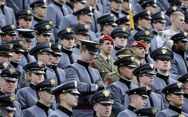 Cadets listen to a public address announcement remembering victims of Friday's attacks in Paris during a timeout in the first half of an NCAA college football game against Tulane on Saturday, Nov. 14, 2015, in West Point, N.Y. (AP Photo/Mike Groll)