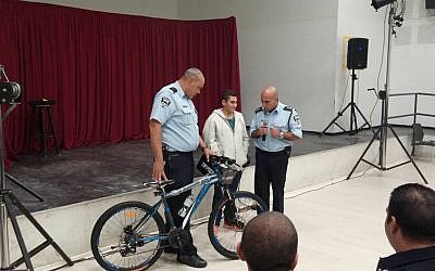 13-year-old Naor, hurt in a October 12 stabbing attack in Pisgat Zeev, receives a new bicycle from police on November 9, 2015 (Facebook photo)