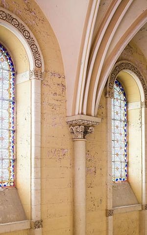 The stained glass windows and thickly painted walls of the former hospital, before restoration (Courtesy Amit Geron)