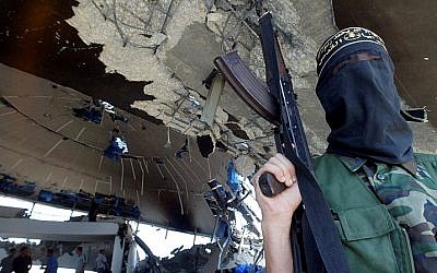 Illustrative image of an armed member of the Islamic Jihad Movement standing inside the ruins of the Netzarim synagogue on September 12, 2005. (Ahmad Khateib /Flash90)