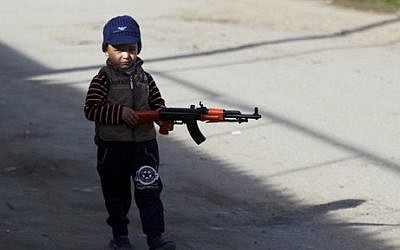 In this photo taken Sunday, Nov. 15, 2015, a boy walks with a toy machine gun in the village of Berikei, Dagestan, Russia. (Sergei Grits/AP)