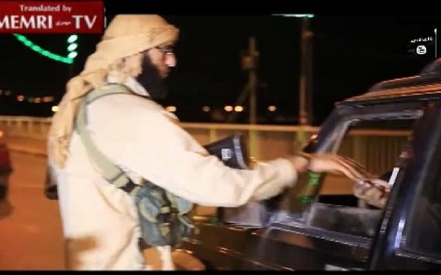 A screenshot from a MEMRI video showing an Islamic State member handing out candy to passing drivers to celebrate the downing of the Russian passenger plane on October 31, 2015. MEMRI) A screenshot from a MEMRI video showing an Islamic State member handing out candy to passing drivers to celebrate the downing of the Russian passenger plane on October 31, 2015. MEMRI)