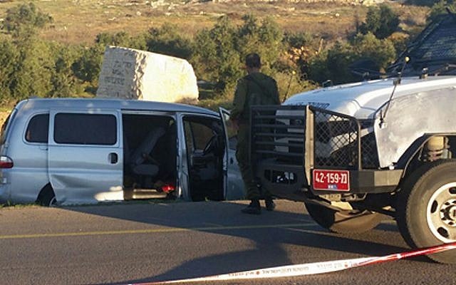 Israeli security forces attend the site of a deadly terror attack in the West Bank on November 13, 2015. The Israeli vehicle in which a father and his son were shot dead is in the background (screen capture: Channel 2)