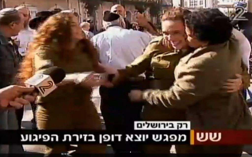Umm al-Fahm woman Hawala Jaber (right) hugs and kisses a female IDF soldier a short time after a terror attack in Jerusalem on November 23, 2015. Jaber was earlier interviewed by Channel 2 and criticized the recent wave of Palestinian terror attacks. (screen capture: Channel 2)