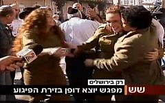 Umm al-Fahm woman Hawala Jaber (right) hugs and kisses a female IDF soldier a short time after a terror attack in Jerusalem on November 23, 2015. Jaber was earlier interviewed by Channel 2 and criticized the recent wave of Palestinian terror attacks. (screen capture: Channel 2)