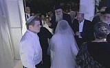Sarah Litman and Ariel Biegel under huppah at their wedding on November 26, 2015 (screen capture: YouTube)