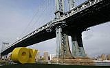 A bright yellow monumental sculpture by artist Deborah Kass sitting below the Manhattan Bridge in New York City November 11, 2015 (Kathy Willens/AP)