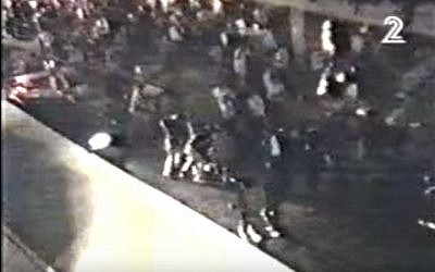 A screen capture from an amateur video showing bodyguards and police jumping on Yitzhak Rabin assassin Yigal Amir in Tel Aviv on November 4, 1995. (screen capture: via YouTube)