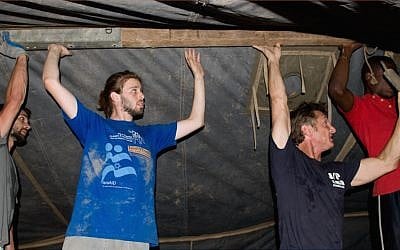 Actor Sean Penn in black t-shirt helping Tevel b'Tzedek volunteers following the earthquake in Haiti, 2010 (photo courtesy Tevel b'Tzedek)