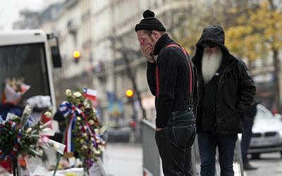File: US rock group Eagles of Death Metal frontman Jesse Hughes (L) and guitarist Dave Catching pay tribute to the victims of the November 13 Paris terror attacks at a makeshift memorial in front of the Bataclan concert hall on December 8, 2015 in Paris. (AFP/Miguel Medina)