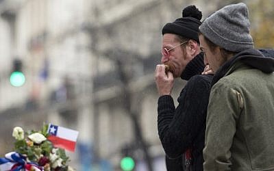 Singer of the US rock group Eagles of Death metal Jesse Hughes (L) and drummer Julian Dorio pay tribute to the victims of the November 13 Paris terrorist attacks at a makeshift memorial in front of the Bataclan concert hall in Paris on December 8, 2015.  (Miguel Medina/AFP)