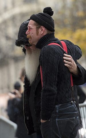 Singer of the US rock group Eagles of Death metal Jesse Hughes (R) and guitarist Dave Catching cry together at a makeshift memorial for the victims of the November 13 Paris terrorist attacks at the Bataclan concert hall in Paris on December 8, 2015. (Miguel Medina/AFP)