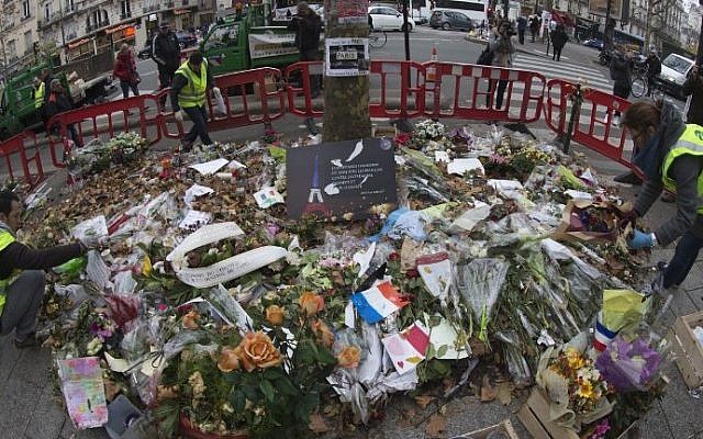 City agents collect objects from the makeshift memorial in tribute to the victims of the Paris attacks outside the Bataclan concert hall in Paris on December 10, 2015. (AFP / JOEL SAGET) City agents collect objects from the makeshift memorial in tribute to the victims of the Paris attacks outside the Bataclan concert hall in Paris on December 10, 2015. (AFP / JOEL SAGET)