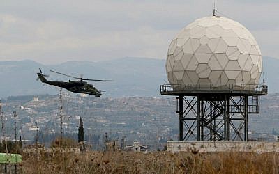 A helicopter flies near a radar at the Russian Hmeimin military base in Latakia province, in the northwest of Syria, on December 16, 2015. (Paul Gypteau/AFP)