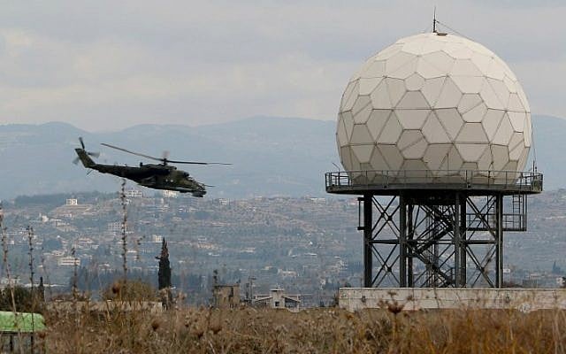 A helicopter flies near a radar at the Russian Hmeimin military base in Latakia province, in the northwest of Syria, on December 16, 2015. (Paul Gypteau/AFP)