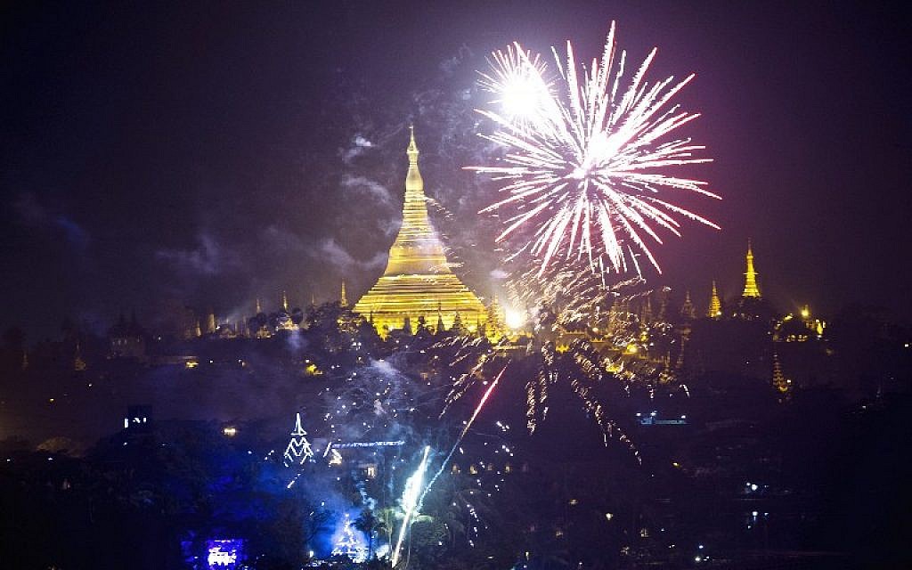 Firework are seen near the Myanmar landmark Shwedagon pagoda during the New Year countdown at the Kandawgyi Park in Yangon on January 1, 2016.  (AFP / YE AUNG THU)