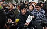 A man shows a newspaper article about Christmas Eve's clash in which two firefighters and a police officer were injured at the poor Jardins de l'Empereur housing estate, to journalists during a demonstration in Ajaccio, Corsica on December 27, 2015, after France banned demonstrations in part of the Corsican capital following two days of anti-Arab protests and sectarian tensions. (AFP/Yannick Graziani)