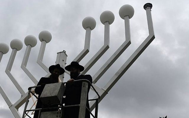 Two rabbis stand on a elevated platform as a giant eight-branched Hanukkah candelabrum is installed in front of the Brandenburg Gate in Berlin on December 4, 2015, two days before the start of the eight-day Jewish holiday. (AFP Photo/Tobias Schwarz) Two rabbis stand on a elevated platform as a giant eight-branched Hanukkah candelabrum is installed in front of the Brandenburg Gate in Berlin on December 4, 2015, two days before the start of the eight-day Jewish holiday. (AFP Photo/Tobias Schwarz)