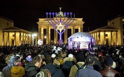 People stand in front of a giant menorah in front of the Brandenburg Gate in Berlin on December 6, 2015. (Jorg Carstensen/DPA/AFP)
