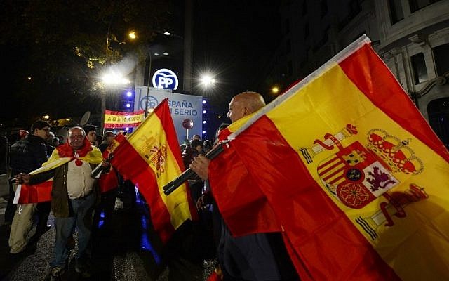 Popular Party (PP) supporters wave Spanish flags in front of the party's headquarters after the partial results of Spain's general elections in Madrid on December 20, 2015. (AFP/Jose Jordan) Popular Party (PP) supporters wave Spanish flags in front of the party's headquarters after the partial results of Spain's general elections in Madrid on December 20, 2015. (AFP/Jose Jordan)