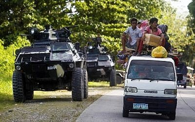 People drive past an armoured personnel carrier (APC) in Kauran, Ampatuan in the southern Philippines province of Maguindanao on December 24, 2015. (AFP PHOTO/MARK NAVALES) People drive past an armoured personnel carrier (APC) in Kauran, Ampatuan in the southern Philippines province of Maguindanao on December 24, 2015. (AFP PHOTO/MARK NAVALES)