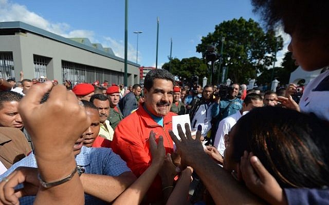Venezuela's President Nicolas Maduro (C) is surrounded by sympathizers as he arrives at the polling station to vote in the legislative election, in Caracas, on December 6, 2015. (AFP PHOTO/LUIS ROBAYO / AFP / LUIS ROBAYO)