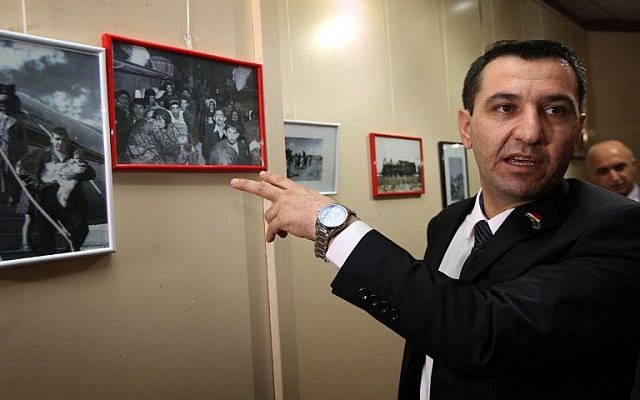 Sherzad Omar Mamsani, the Jewish representative at the Kurdish regional ministry, looks at photographs displayed during a ceremony marking the deportation of Jews from Iraq seven decades ago, in Arbil, the capital of the autonomous Kurdish region of northern Iraq, November 30, 2015. (AFP/SAFIN HAMED)