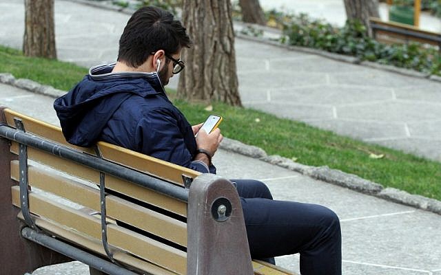An Iranian man uses a smartphone at a park in Tehran on December 1, 2015. (AFP PHOTO / ATTA KENARE / AFP / ATTA KENARE) An Iranian man uses a smartphone at a park in Tehran on December 1, 2015. (AFP PHOTO / ATTA KENARE / AFP / ATTA KENARE)
