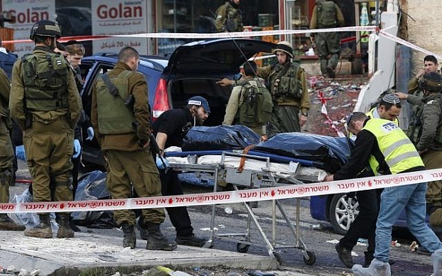 Israeli security forces and forensics transport the body of Mazen Aribe, who was shot following an attack at the Hizme checkpoint, north of Jerusalem, on December 3, 2015. (AFP/Ahmad Gharabli)