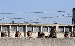 Members of the Syrian government forces look on as hundreds of civilians and Syrian rebel forces begin evacuating the last opposition-held district of Waer in the central city of Homs, under a deal with the Syrian regime, December 9, 2015. (AFP/Louai Beshara)