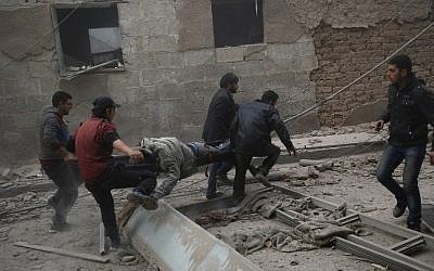 Syrians evacuate victims following airstrikes on the town of Douma in the eastern Ghouta region, a rebel stronghold east of the capital, Damascus, on December 13, 2015. (AFP/Sameer al-Doumy)