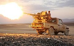 A Yemeni tribesman from the Popular Resistance Committees, supporting forces loyal to Yemen's Saudi-backed President Abedrabbo Mansour Hadi, fires a machine gun in the area of Sirwa, east of the capital Sanaa on December 14, 2015. AFP/ABDULLAH AL-QADRY)