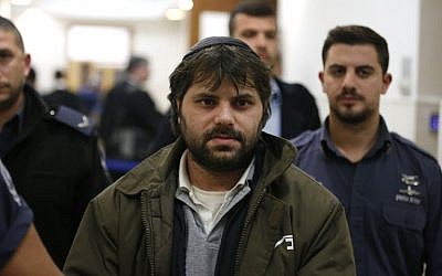 Yosef Ben David,  the prime suspect, who was charged along with two minors for the abduction and murder of the Palestinian teenager Mohammed Abu Khdeir, is escorted by Israeli policemen at the district court in Jerusalem on December 20, 2015.