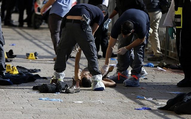 Israeli forensic police stand next to the body of a Palestinian attacker who was shot dead as he stabbed Israelis outside the Jaffa Gate of the Old City, Jerusalem, December 23, 2015. (AFP/AHMAD GHARABLI)
/ AFP / AHMAD GHARABLI Israeli forensic police stand next to the body of a Palestinian attacker who was shot dead as he stabbed Israelis outside the Jaffa Gate of the Old City, Jerusalem, December 23, 2015. (AFP/AHMAD GHARABLI)
/ AFP / AHMAD GHARABLI