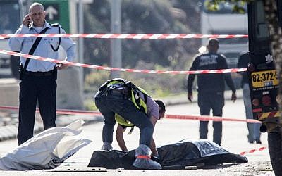 An Israeli forensic policeman stands next to the body of a Palestinian assailant who was shot dead after he stabbed two Israeli security guards at the Barkan Industrial Zone next to the settlement of Ariel, December 24, 2015. (Phot by AFP Photo/Jack Guez)