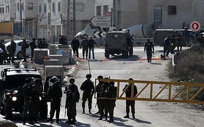 Israeli security forces work at the scene where a Palestinian assailant was shot dead after he tried to stab Israeli security forces with a screwdriver, south of the West Bank city of Hebron, December 24, 2015. (Photo by AFP Photo/Hazem Bader)