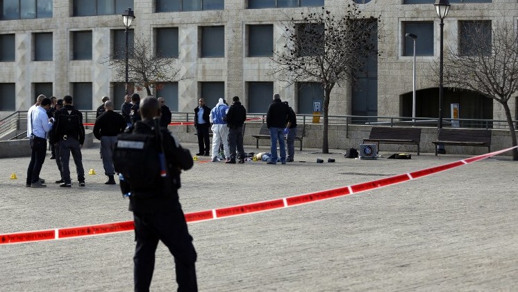 Forensic policemen stand next to the body of a Palestinian assailant who was shot dead following an attack on December 26, 2015, near Jerusalem's Old City (Ahmad Gharabli/AFP)