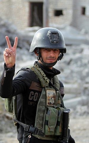 A member of Iraq's elite counter-terrorism service flashes the V for victory sign on December 27, 2015 in the Hoz neighbourhood in central Ramadi, during military operations against the Islamic State. (AFP PHOTO/AHMAD AL-RUBAYE)