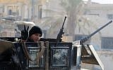 A member of Iraq's elite counter-terrorism service flashes the 'V' for victory sign on December 29, 2015 in the city of Ramadi, the capital of Iraq's Anbar province, about 110 kilometers west of Baghdad, after Iraqi forces recaptured it from the Islamic State jihadist group. (AFP Photo/Ahmad Al-Rubaye)