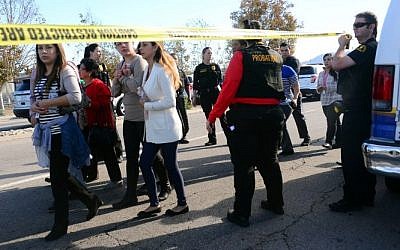 Survivors are evacuated from the scene of a shooting under police and sheriff escort on December 2, 2015 in San Bernardino, California.  (AFP PHOTO/FREDERIC J. BROWN)