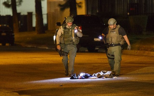 Law enforcement officers investigate a suspicious bag, later found not to be a threat, on Victoria Avenue after a mass shooting at the Inland Regional Center on Wednesday, December 2, 2015 in San Bernardino, California. (AFP PHOTO / PATRICK T.  FALLON)