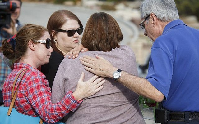 A woman identified as the fiancée of shooting victim (C) is comforted by Chaplain Steve Ballinger (R) as she leaves flowers on December 3, 2015, near the site of a mass shooting at the Inland Regional Center where 14 people were killed on December 2 in San Bernardino, California. (AFP PHOTO/PATRICK T. FALLON) A woman identified as the fiancée of shooting victim (C) is comforted by Chaplain Steve Ballinger (R) as she leaves flowers on December 3, 2015, near the site of a mass shooting at the Inland Regional Center where 14 people were killed on December 2 in San Bernardino, California. (AFP PHOTO/PATRICK T. FALLON)