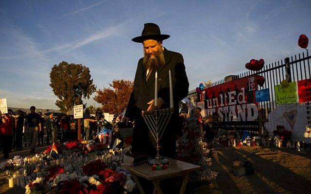 Rabbi Sholom Harlig prepares to light the menorah for the first night of Hanukkah at a makeshift memorial near the Inland Regional Center in the aftermath of a mass terror shooting that killed 14 people on Sunday, December 6, 2015 in San Bernardino, California. (AFP Photo/Patrick T. Fallon) Rabbi Sholom Harlig prepares to light the menorah for the first night of Hanukkah at a makeshift memorial near the Inland Regional Center in the aftermath of a mass terror shooting that killed 14 people on Sunday, December 6, 2015 in San Bernardino, California. (AFP Photo/Patrick T. Fallon)
