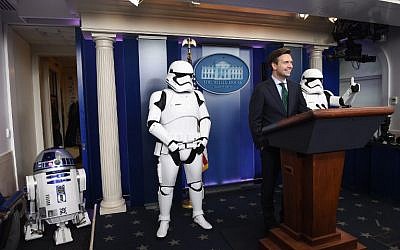 US Press Secretary Josh Earnest speaks to the press in the briefing room at the White House in Washington, DC, on December 18, 2015, accompanied by R2D2 and Storm Troopers. The new Star Wars movie 'The Force Awakens' was shown at the White House for children of military families. (AFP PHOTO/NICHOLAS KAMM)