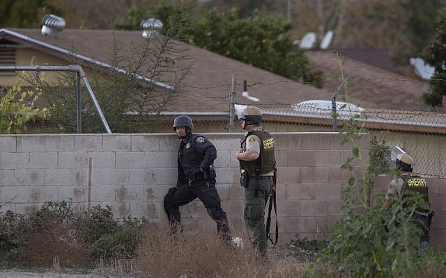 Law enforcement officers search for a possible suspect following a shootout with suspects of a mass shooting at the Inland Regional Center by multiple gunmen on December 2, 2015 in San Bernardino, California. (David McNew/Getty Images/AFP)