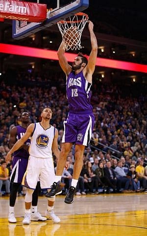 Omri Casspi #18 of the Sacramento Kings dunks the ball over Stephen Curry #30 of the Golden State Warriors at ORACLE Arena on December 28, 2015 in Oakland, California (Ezra Shaw/Getty Images/AFP)