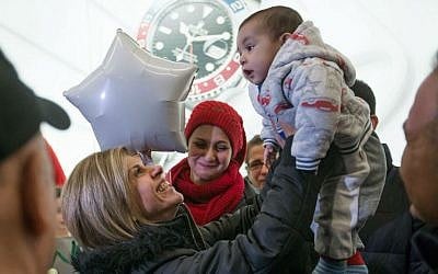 Tima Kurdi, left, who lives in the Vancouver area, lifts up her 5-month-old nephew Sherwan Kurdi after her brother Mohammad Kurdi and his family, who escaped conflict in Syria, arrived at Vancouver International Airport, Monday, Dec. 28, 2015, in Richmond, British Columbia. (Darryl Dyck/The Canadian Press via AP)