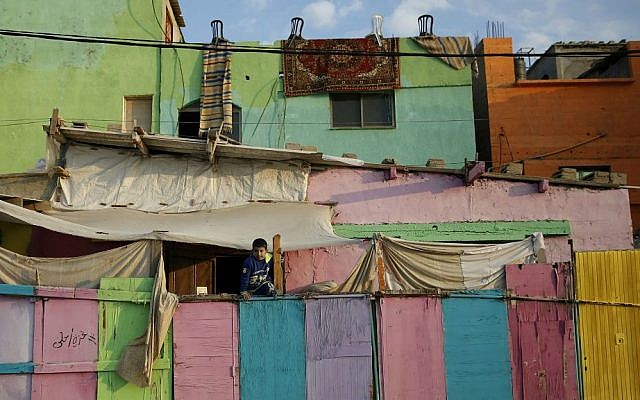 In this Saturday Dec. 19, 2015 photo, a Palestinian boy climbs on a painted wall in the Shati refugee camp in Gaza City. (AP Photo/Hatem Moussa)