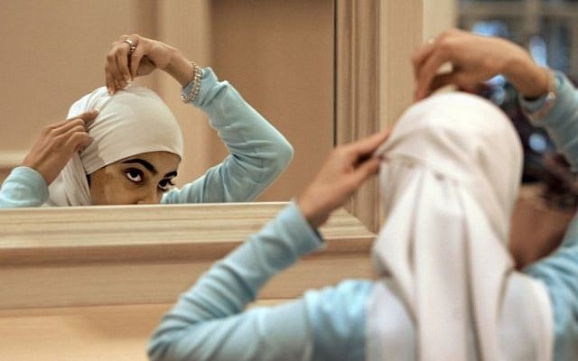 Illustrative photo of a Muslim woman adjusting her hijab. (AP/M. Spencer Green, File)