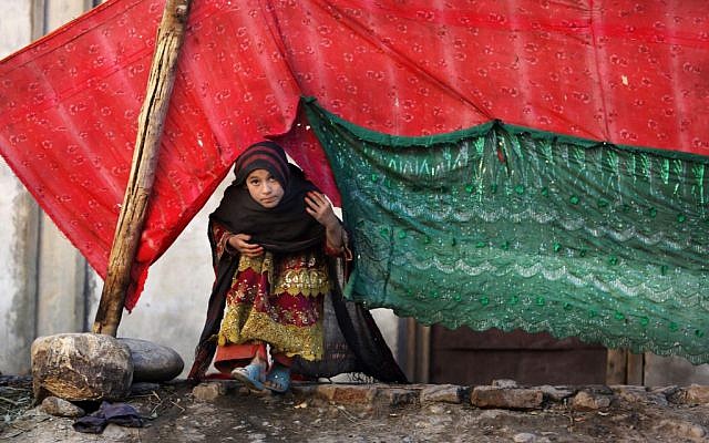 In this Nov. 29, 2015 photo, an internally displaced girl peeks from a tent after her family left their village in Rodat district of Jalalabad, Afghanistan. Nangarhar’s chief refugee official says that at least 25,200 families, or more than 170,000 people, have been displaced across the province, either by Islamic State or perceived threats from the group. (AP Photo/Rahmat Gul) In this Nov. 29, 2015 photo, an internally displaced girl peeks from a tent after her family left their village in Rodat district of Jalalabad, Afghanistan. Nangarhar’s chief refugee official says that at least 25,200 families, or more than 170,000 people, have been displaced across the province, either by Islamic State or perceived threats from the group. (AP Photo/Rahmat Gul)
